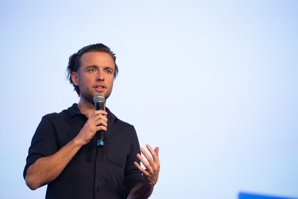 Jude Kriwald speaking to a keynote audience. Photo Credit ABonfils